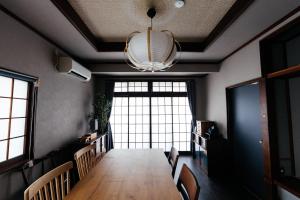 a dining room with a long table and a chandelier at 松本市の一棟貸しのプライベート邸宅 in Matsumoto