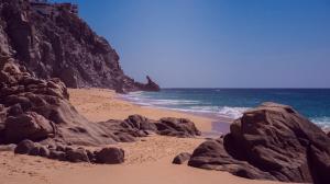 a sandy beach with rocks and the ocean at Casa del Vistas Pedregal in Cabo San Lucas +24 photos