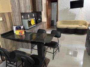 a living room with a table with chairs and a tv at Complejos Residenciales Las Lomitas in San Lorenzo de la Frontera