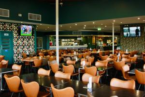 a restaurant with tables and chairs and a bar at The Mayfair Emerald in Emerald