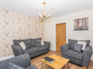 a living room with two couches and a table at Court Terrace in Ripon