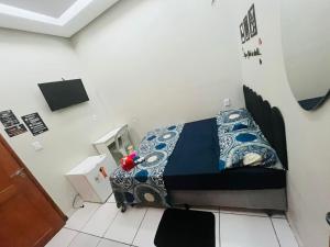 a small bedroom with a bed with blue and white sheets at Hotel Big Burg in Breves