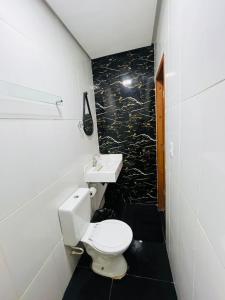 a bathroom with a white toilet and a sink at Hotel Big Burg in Breves
