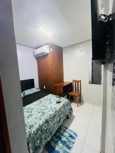 a small bedroom with a bed and a desk at Hotel Big Burg in Breves +2 photos