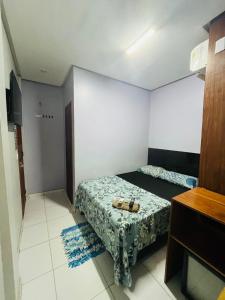 a small bedroom with a bed and a tv at Hotel Big Burg in Breves