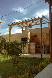 a wooden pergola in a yard with a stone oven at Wind Village Icaraizinho in Icaraí