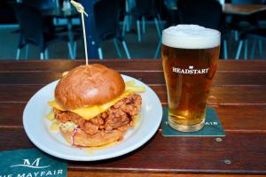 a sandwich and a glass of beer on a table at The Mayfair Emerald in Emerald
