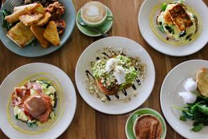 a wooden table with plates of food on it at The Mayfair Emerald in Emerald