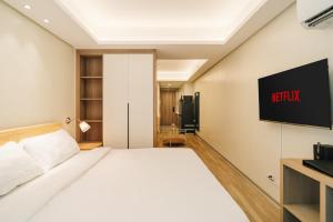 a bedroom with a bed and a tv on a wall at Dragon's Keep BNB near NAIA and MOA in Manila