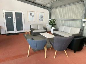 a living room with couches and a table and chairs at Mudgee Vineyard Motor Inn in Mudgee