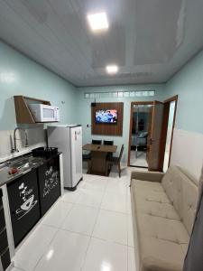 a kitchen and living room with a couch and a tv at APART HOTEL Wm in Belém +14 photos