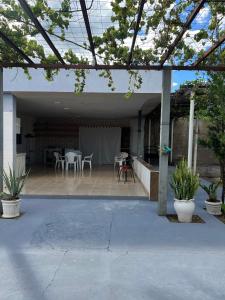 a patio with tables and chairs in a house at Casa Lagoa Maior Espaçosa e confortável! in Três Lagoas