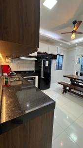 a kitchen with a counter top and a black refrigerator at Casa ampla em belém in Belém