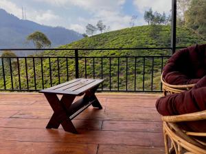 a wooden table on a deck with a view of a hill at Seeming Lodge in Nuwara Eliya