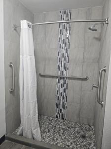a shower with a shower curtain in a bathroom at Super 8 by Wyndham Hobbs in Hobbs