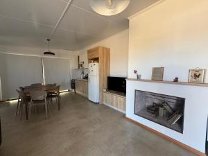 a living room with a fireplace and a dining table at Refugio del Indalo in Termas de Guaviyú