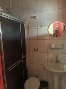 a man taking a picture of a bathroom with a toilet and sink at Pousada Morada dos Guarás in Ilha Comprida +9 photos