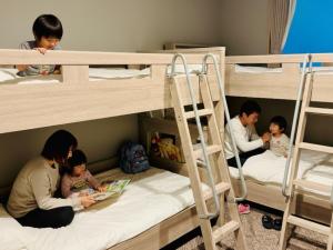 a group of people sitting on bunk beds at BANDE Hotel in Namba in Osaka