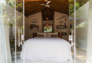 a bedroom with a white bed in a room at LAUS Bangalôs Experience - Piscina Privativa - Praia de Algodões - Península de Maraú - Bahia in Praia dos Algodões