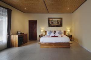 a bedroom with a bed and a painting on the wall at Selau Asry in Sidemen