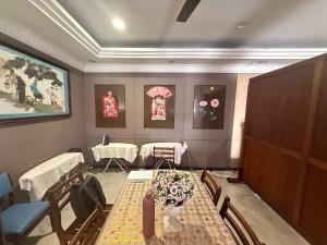 a waiting room with a table and chairs and flowers at Anika Inn Kluang in Kluang