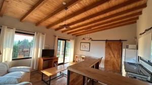 a living room with wooden ceilings and a table at Patagonia in Trevelín