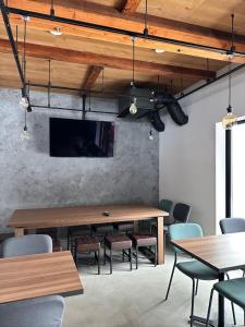 a conference room with tables and chairs and a tv at LOCOMOTION COFFEE AND BED in Tateyama +24 photos