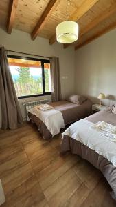 a bedroom with two beds and a large window at Patagonia in Trevelín