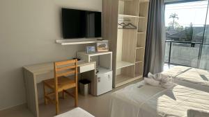 a bedroom with a desk and a bed and a television at Oceane Norte Hotel in Parnaíba