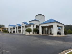 a large white building with blue roof at EXPRESS INN Troy in Troy