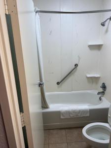 a bathroom with a bath tub and a toilet at EXPRESS INN Troy in Troy +5 photos