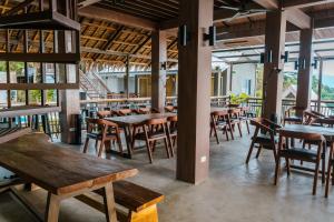 an empty restaurant with wooden tables and chairs at The Shack Hideaway by Mayumi Resorts in Mabini