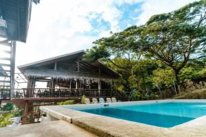 a swimming pool in front of a building at The Shack Hideaway by Mayumi Resorts in Mabini
