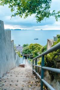 a stairway leading to the ocean with a fence at The Shack Hideaway by Mayumi Resorts in Mabini