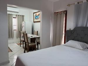 a bedroom with a bed and a table with chairs at kitnet Ceu in Campo Grande