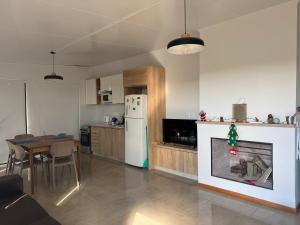 a kitchen with a fireplace and a table and a refrigerator at Refugio del Indalo in Termas de Guaviyú +17 photos