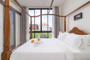 a bedroom with a white bed with a large window at Zen Villa - Central Canggu in Canggu +101 photos