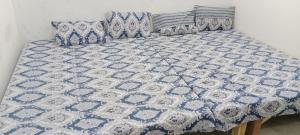 a bed with a blue and white quilt on it at Hari Sharnam Residency in Mathura