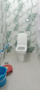 a bathroom with a white toilet and a wall at Hari Sharnam Residency in Mathura +19 photos