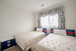 a bedroom with two beds and a window at Neat and tidy house in Cranbourne