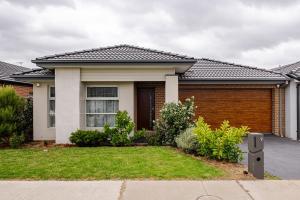 a house with a grass yard in front of it at Neat and tidy house in Cranbourne