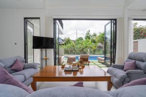 a living room with two couches and a table at Zen Villa - Central Canggu in Canggu