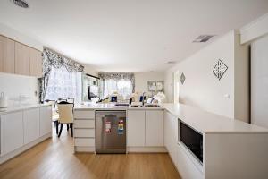 a kitchen with white cabinets and a counter top at Neat and tidy house in Cranbourne