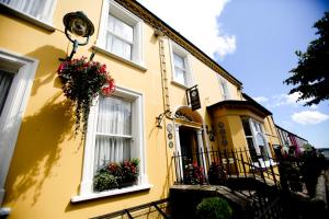 a yellow house with flower boxes on the side of it at Dufferin Coaching Inn in Killyleagh