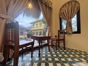 a room with a piano and two chairs and a window at The Hue Verandah in Thôn Trường Giang