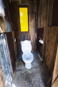 a bathroom with a white toilet in a wooden room at ไทไอดิน in Ban Khui Khwang