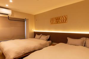 two beds in a hotel room with at The Residence Sapporo - すすきの駅から徒歩6分 - in Sapporo