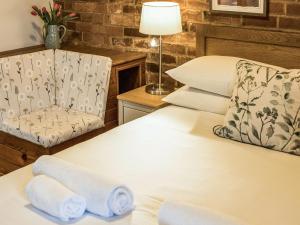 a hotel room with a bed and a chair at Yarlington Mill in Ledbury +5 photos