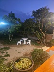 a patio with a table and two white benches at Khiri&Kiwi homestay in Ban Mae Rim Nua