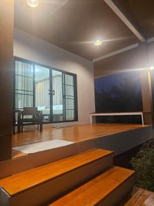 a room with a wooden floor and a large window at Khiri&Kiwi homestay in Ban Mae Rim Nua